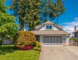 A detached matrimonial home in Ontario with a grey exterior and manicured lawn, representing property rights and division during a divorce.